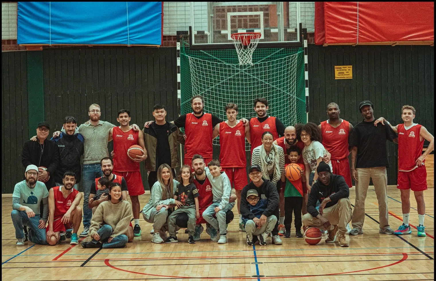 MBA-laget i röda matchställ tillsammans med familjer